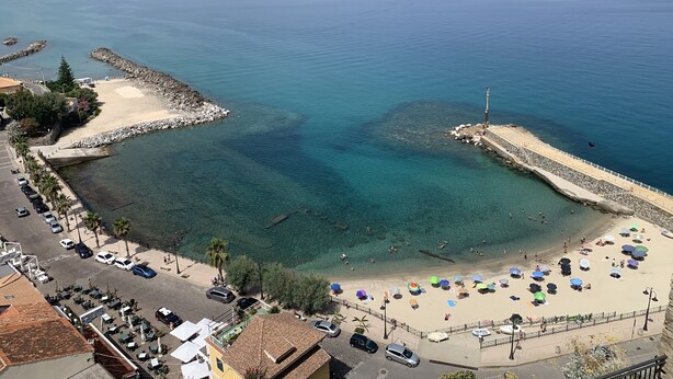 A coastal area with a sandy beach, clear blue waters, and a rocky breakwater. - Anna's HOUSE - Solarium Terrace (Pizzo)