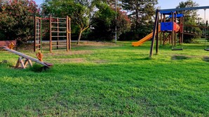 A playground with a seesaw, climbing frame, and slide. - Anna's HOUSE - Solarium Terrace (Pizzo)