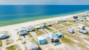 An aerial view of a coastal residential area with houses, a beach, and the ocean. - Luxury Coastal Retreat | Gulf Views | Private Elevator (Gulf Shores)