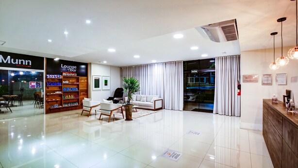 Un moderno vestíbulo de hotel con mostrador de recepción, zona de estar y bar lounge.