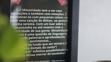 A framed quote about mineiridade, a plate of food, and a cup.