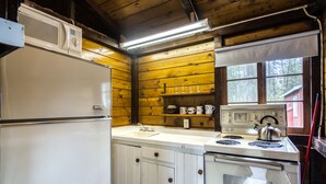 Una cocina compacta equipada con refrigerador, estufa, microondas y lavaplatos.
