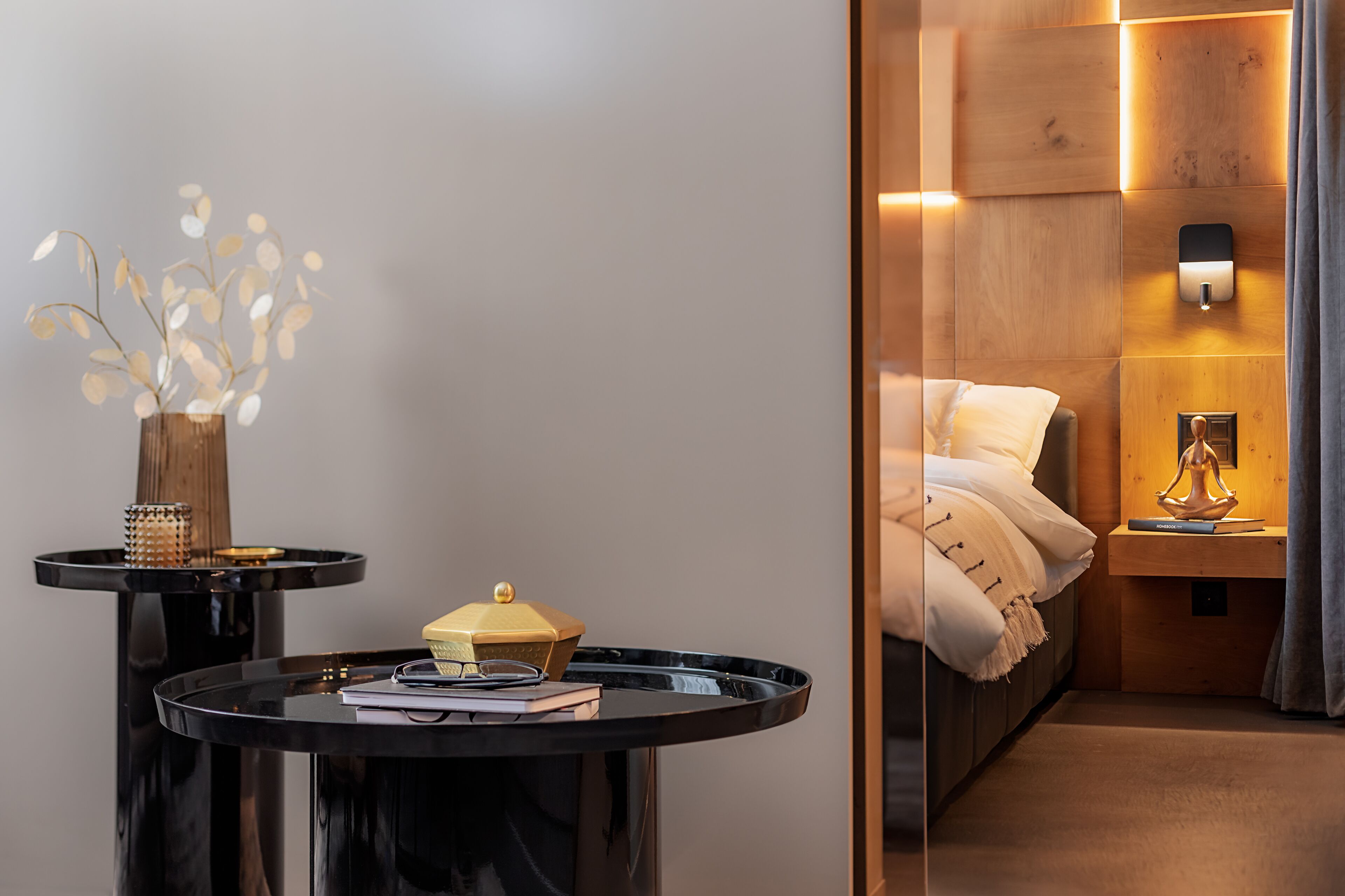 Habitación de hotel moderna con cama, mesita de noche y aplique de pared.