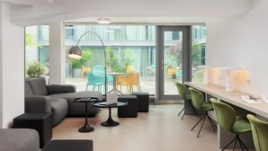 Una sala de estar moderna con un sofá, una mesa de centro y un comedor con sillas y una mesa.