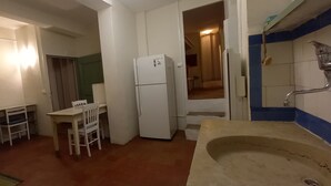 A compact kitchen with a refrigerator, a sink, and a dining table with chairs. - 80 m2 in a quiet, cool location, with double rooms, terrace and olive grove. (Aix-en-Provence)