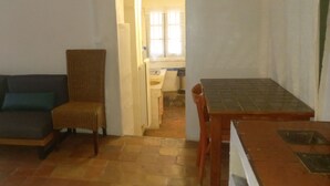 A room with a sofa, a chair, a table, and a window. - 80 m2 in a quiet, cool location, with double rooms, terrace and olive grove. (Aix-en-Provence)