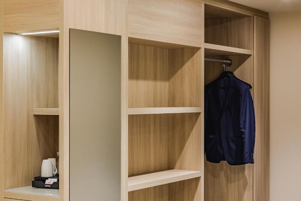 A wooden wardrobe with multiple shelves and a hanging rod.