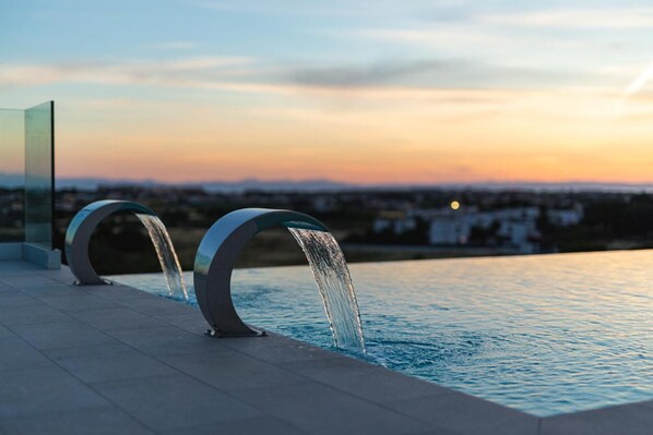 En säsongsöppen utomhuspool och solstolar