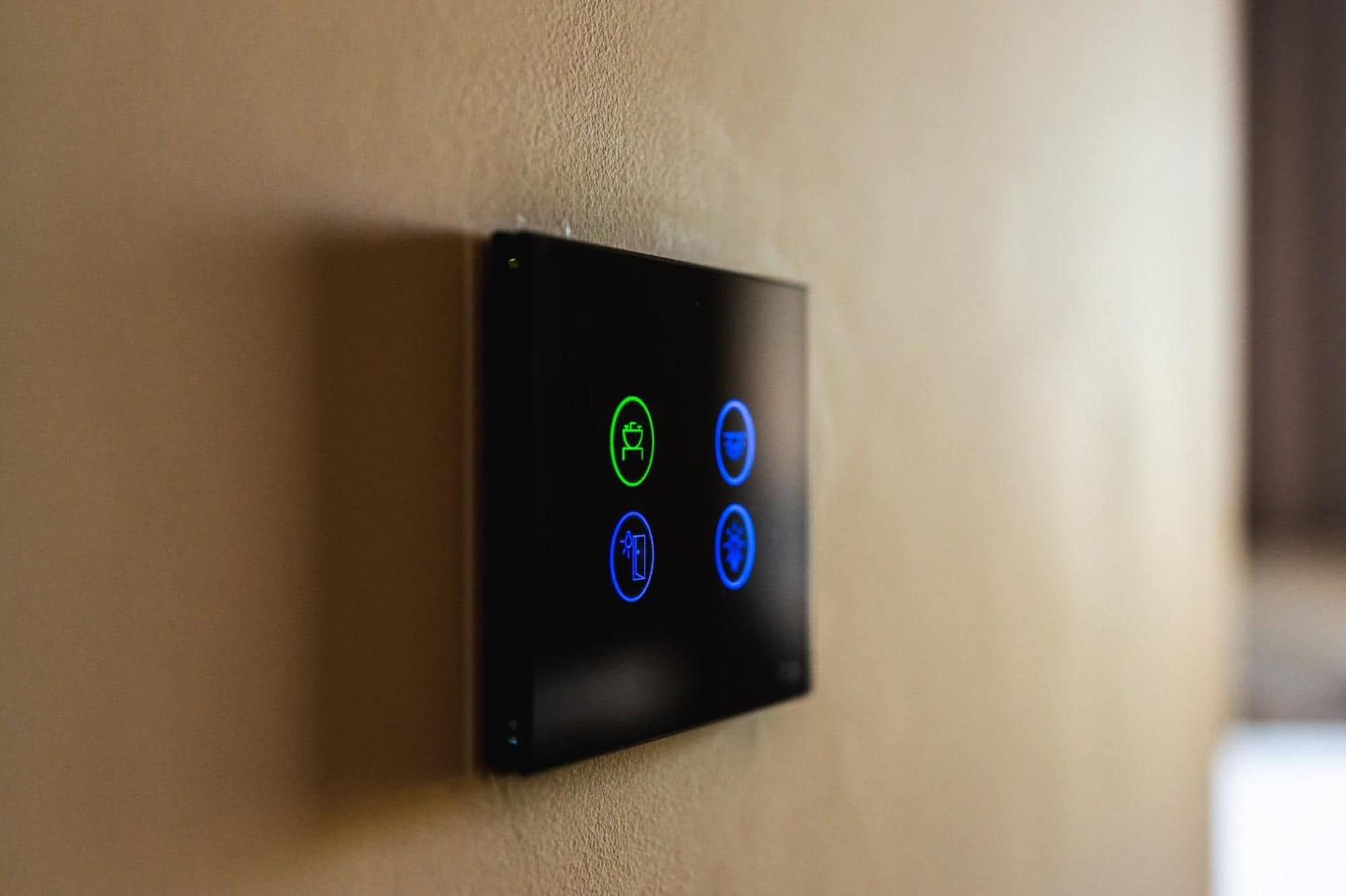 A control panel with illuminated icons on a wall.