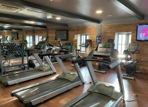 A gym with treadmills, weight machines, and a mirrored wall. - Sandy Feet 1st floor apartment with open plan living on The Bay, Filey (Primrose Valley)