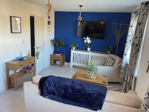 A living room with a sofa, a coffee table, a TV, and a door.