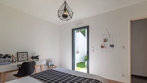 Makuuhuoneessa on sänky, työpöytä, tuoli, riippuvalaisin ja ovi, joka johtaa parvekkeelle.