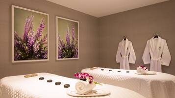 Experience a serene spa retreat with two massage tables, framed botanical paintings, and soothing ambiance.