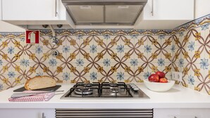 A kitchen with a gas stove, a bread loaf, and a bowl of apples. - Casa da Avenida I in Lisboa (Lisbon)