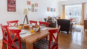 A dining area with a wooden table, red chairs, and a breakfast setting. - Casa da Avenida III (Lisbon)