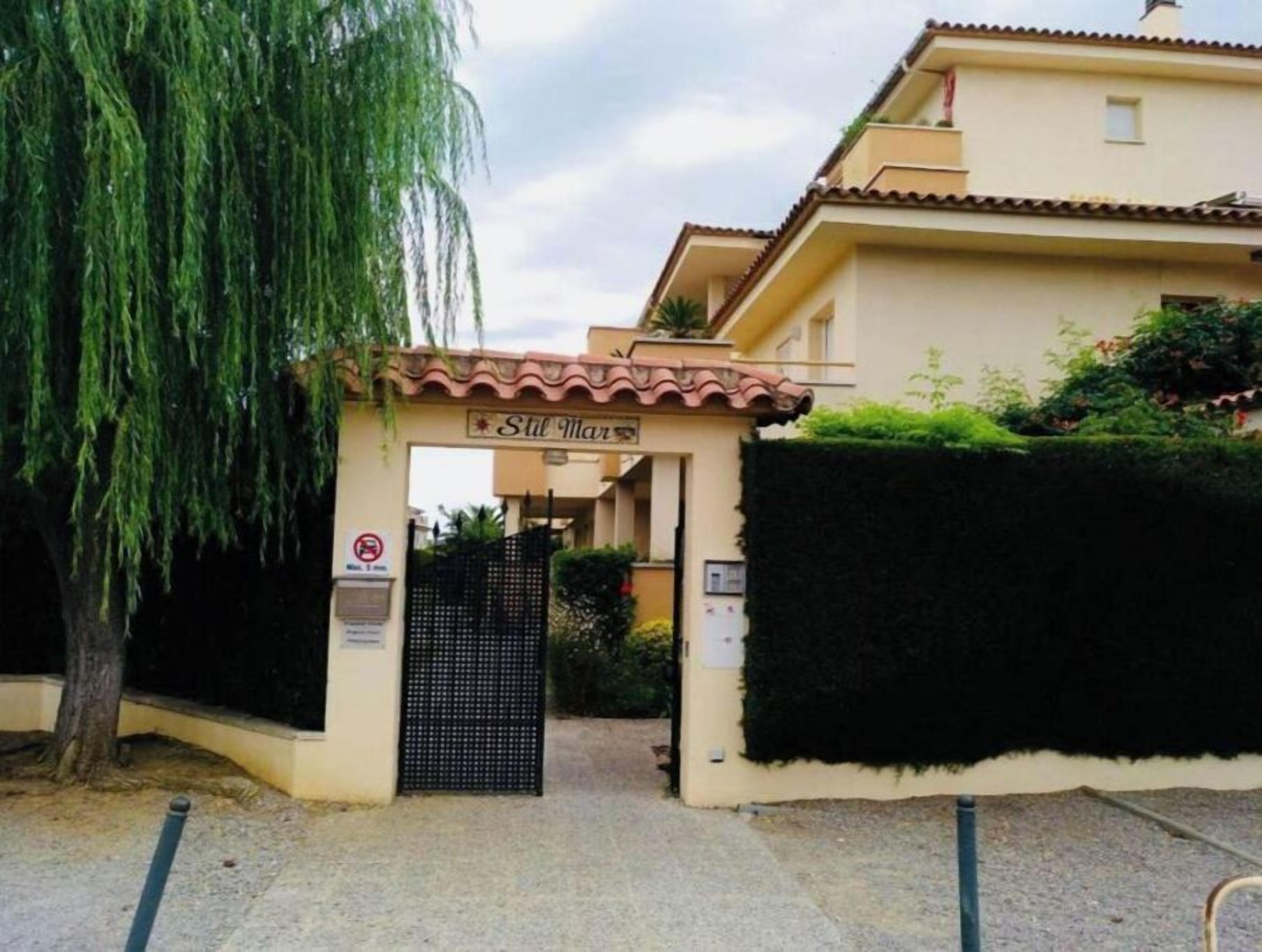 A gated entrance to a building with a sign reading "Still Mar".