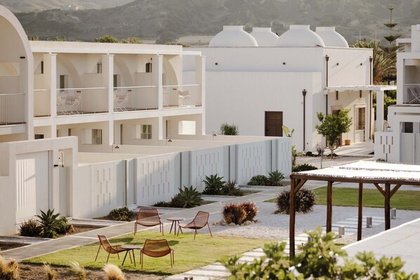 A modern hotel with a courtyard featuring outdoor seating and a pool. - ALERO Seaside Skyros Resort (Skiros)