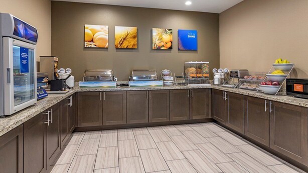 A hotel kitchen with a self-service breakfast bar, a refrigerator, and wall-mounted pictures. - Chic hotel with AC and fitness room in marvelous Houston (Houston)