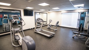 A fitness center with treadmills, elliptical machines, and weight machines. - Chic hotel with AC and fitness room in marvelous Houston (Houston)