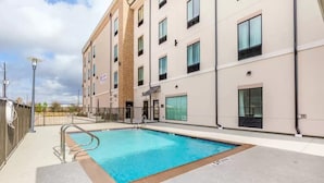 A hotel with a swimming pool, a brick column, and a modern facade. - Chic hotel with AC and fitness room in marvelous Houston (Houston)