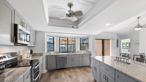 A modern kitchen with granite countertops, stainless steel appliances, and a large island. - SEASIDE VILLA MANATEE BAY in quiet location on Pine Island (Saint James City)