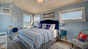 A bedroom with a large bed, a desk, a chair, and a view of the ocean. - Enjoy this oceanfront 3-bedroom Sea Rie-Treat, in North Topsail Beach. (North Topsail Beach)
