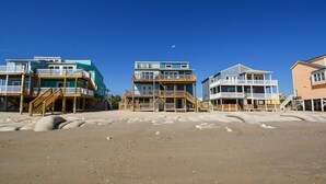 Beachfront buildings with balconies, wooden walkways, and a clear blue sky. - Enjoy this oceanfront 3-bedroom Sea Rie-Treat, in North Topsail Beach. (North Topsail Beach)