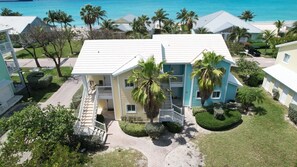Enjoy ocean views from the balcony of this two-story house, surrounded by lush lawns and palm trees.