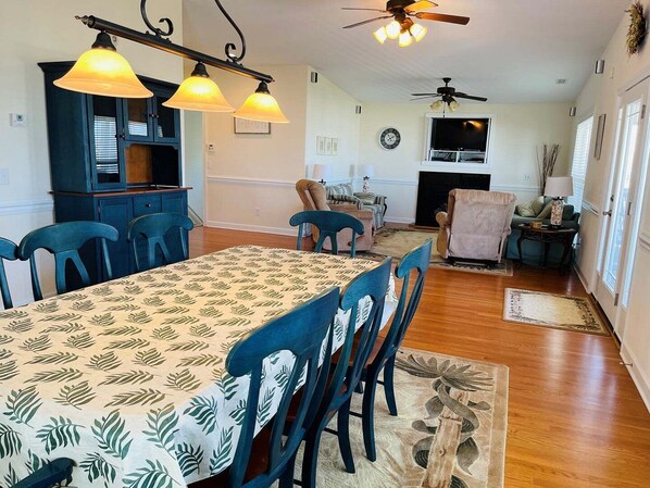 A dining area with a table, chairs, and a ceiling fan.