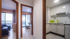 Ein Hotelzimmer mit Balkon, einer Küchenzeile und einem Bett.