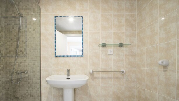 A bathroom with a shower, sink, and mirror. - LUXMAR 2ND  (venidor)