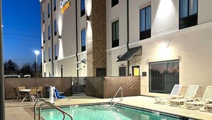 A hotel with a swimming pool, outdoor seating, and a well-lit facade. - Comfort Suites Near Sam Houston Race Park (Houston)