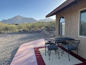 Relax on the patio with a metal table and chairs, surrounded by breathtaking mountain views.