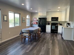 Enjoy meals in the kitchen and dining area with a table for four and a microwave, oven, and refrigerator.