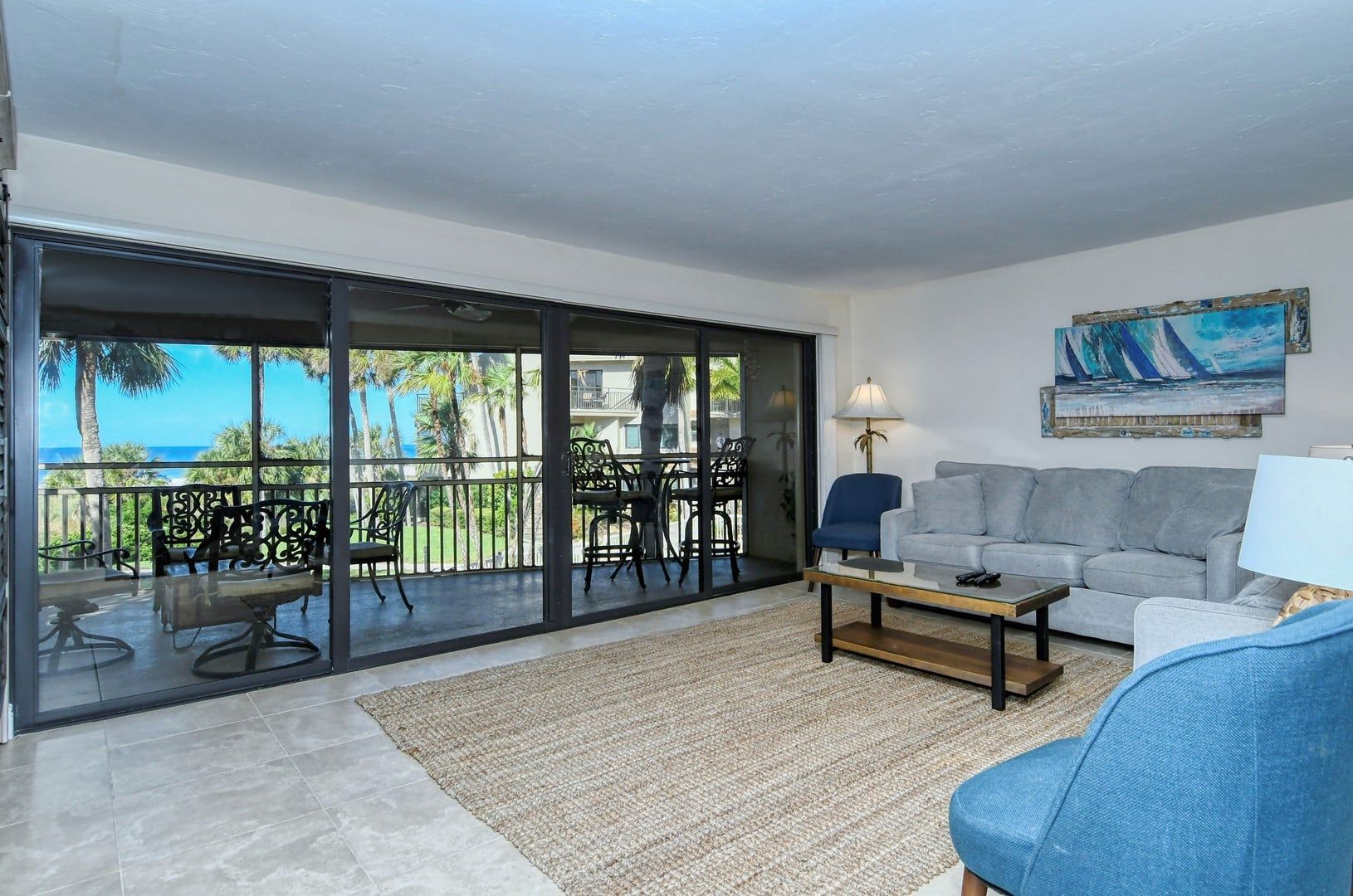 Ein Wohnzimmer mit Balkon, einer Couch, einem Couchtisch und einem Gemälde.