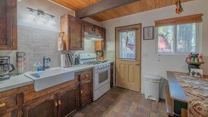 A kitchen with wooden cabinets, a stove, and a sink.