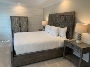 A neatly made bed with white bedding, a wooden headboard, two bedside lamps, and a small bedside table with a lamp. - Family Home Near LakePoint Sports with Fenced Yard (Acworth)
