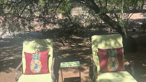 Two sun loungers with floral cushions, a small table, and a decorative chest. - Historic Schoolhouse Flat by Verde Canyon Railroad (Clarkdale)