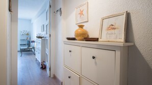 Een hal met een wit kastje, een zeester decoratie en een lijst met een afbeelding.