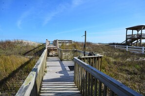 A wooden boardwalk leading to a wooden structure with a roof.