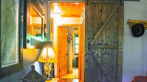 Ein rustikales Interieur mit Holztür, Lampe und Spiegel.