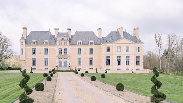 A large, symmetrical building with a central entrance, surrounded by well-manicured lawns and topiary. - Château with Spa, Golf, Tennis, Basket, swimming pools, gardens.  (Villers-Bocage)