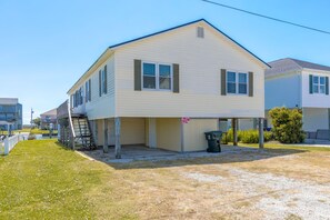 A two-story house with a garage, a visible number '1041', and a small front yard. - Mama's Pride - 3BR Home on the Canal - Boat Dock & Sound Views! (Surf City)