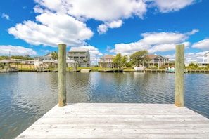 A wooden dock extending into calm water with a clear sky. - Mama's Pride - 3BR Home on the Canal - Boat Dock & Sound Views! (Surf City)