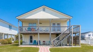 A two-story house with a balcony, a front porch, and a staircase leading to the upper floor.