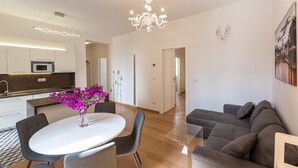 Un espacio habitable moderno con comedor, cocina y zona de estar con sofá.