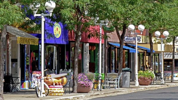 A street with various shops and a bicycle parked on the sidewalk.