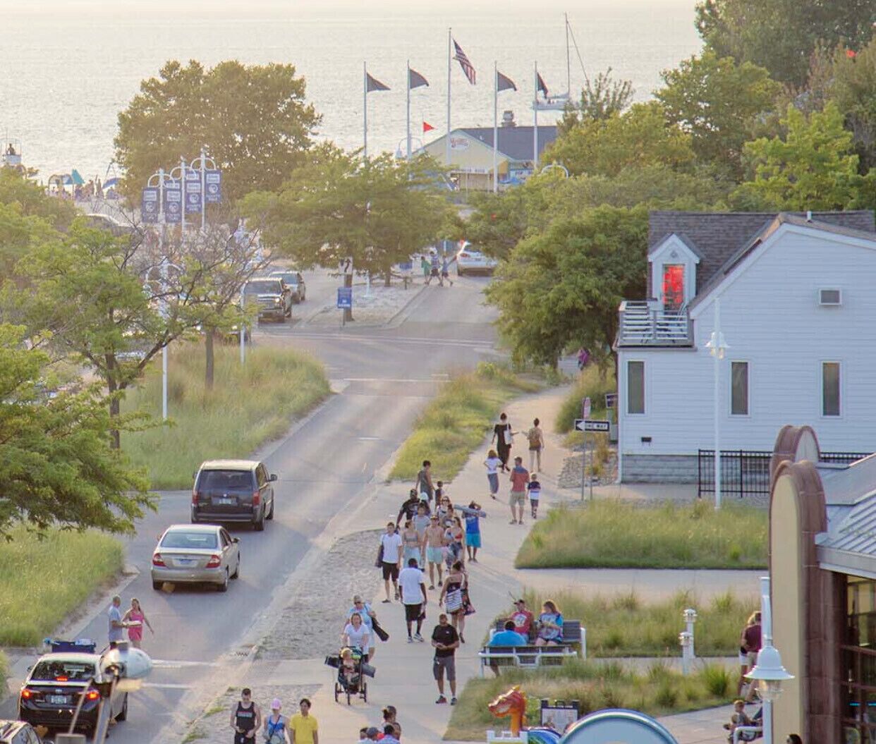 Une route côtière bordée d’un bâtiment blanc, de drapeaux et d’une foule de personnes.