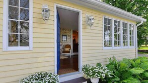 A yellow house with a front door, two windows, and a porch with steps. - The ultimate cottagecore experience in a serene country setting overlooking USA's #1 State Park (Perry)