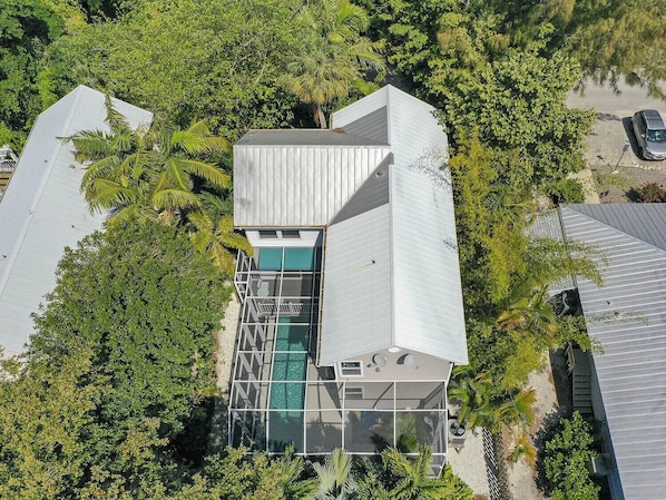 Una casa moderna con un amplio ventanal y una piscina.